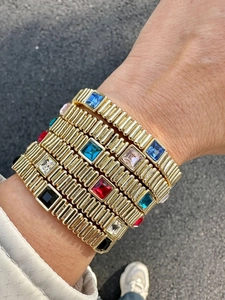 Detail shot of multi-colored square crystal elastic bracelets stacked on a wrist