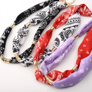 Λεπτομερής όψη κολιέ από μεταξωτό φουλάρι paisley με χρυσά μεταλλικά σπειροειδή τμήματα