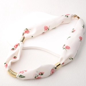 Υφασμάτινο κολιέ με φλοράλ σχέδιο και χρυσές λεπτομέρειες σε λευκή βάση