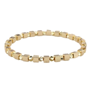 Minimalist gold elastic bracelet featuring textured square beads and polished spheres