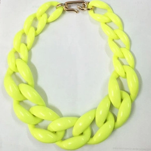 Dettaglio della collana a catena grossa in acrilico giallo fluo con chiusura oro
