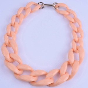 Dettaglio delle maglie della catena in acrilico pesca e chiusura in metallo dorato su collana
