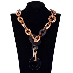 Bohemian leopard print resin link necklace with amber texture on a black display stand