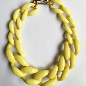 Dettaglio della collana a catena oversize in acrilico giallo limone brillante