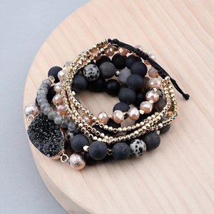 Détail de l'ensemble de bracelets en perles noires mates avec pendentifs druzy dorés