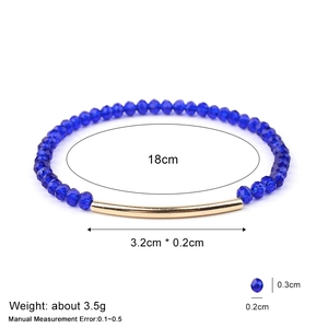 Bracelet en perles de cristal bleu à facettes avec un tube doré sur fond blanc