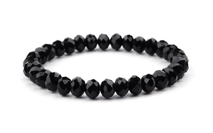 Vue détaillée d'un bracelet de perles noires facettées aux surfaces polies et brillantes