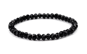 Gros plan sur un bracelet en perles de cristal noir facetté avec finitions polies