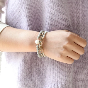 Ensemble de trois bracelets élastiques en perles de cristal et tubes dorés sur poignet