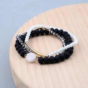 Détail de bracelets bohèmes en perles avec tube doré et pendentif druzy blanc