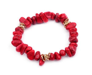 Detailed macro view of irregular red stones and gold crystal spacers on the elastic bracelet