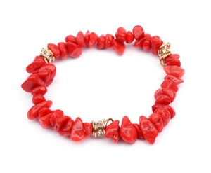 Detail of red irregular natural stone beads and gold-plated rhinestone spacers on a bracelet