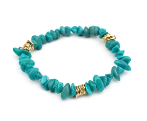 Close-up of irregular turquoise stones and gold rings with sparkling zircon inlay