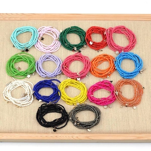 Close-up of colorful Miyuki Tila seed bead bracelets with celestial metal charms