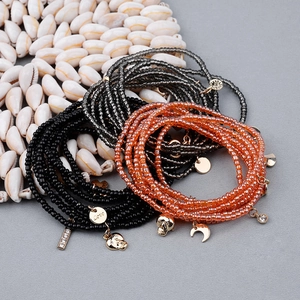 Detail of multi-layer beaded bracelet with LOVE pendant and crescent moon charms