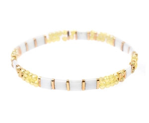 Detalle de la pulsera Miyuki Tila hecha a mano con cuentas blancas, amarillas y oro