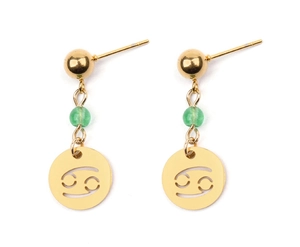 Détail de boucles d'oreilles signe Cancer dorées avec perles vertes et pendentifs