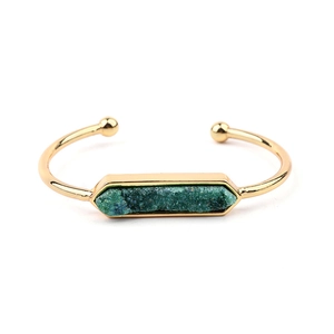 Dettaglio di un bracciale a polsino aperto in oro con pietra naturale druzy verde esagonale
