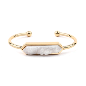 Dettaglio macro della pietra di cristallo druzy bianco esagonale su un bracciale oro