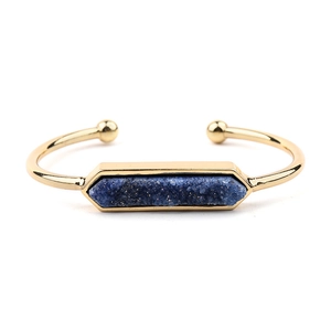 Vista dettagliata del bracciale aperto dorato con pietra druzy blu e sfere finali