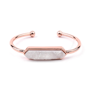 Dettaglio macro del bracciale rigido oro rosa con pietra druzy esagonale bianca