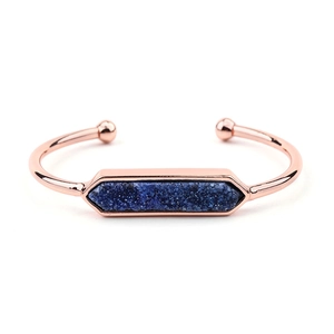 Vista dettagliata di un bracciale aperto in oro rosa con una pietra druzy blu rettangolare