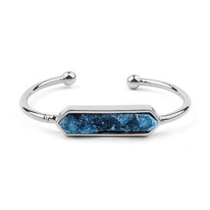 Dettaglio del bracciale rigido argentato con intarsio in pietra druzy blu esagonale