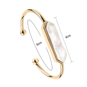 Dettaglio del bracciale rigido dorato con intarsio in pietra di quarzo druzy bianco