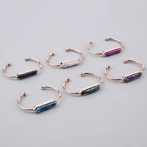 Dettaglio di sei bracciali aperti in oro rosa con pietre druzy esagonali multicolore in set