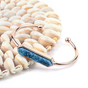 Bracciale rigido aperto oro rosa con una lunga pietra naturale Druzy blu su conchiglie