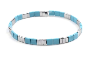 Macro detail of sky blue Tila beads and silver metal spacers on a woven stretch bracelet
