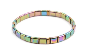 Macro detail of iridescent square Tila beads with golden spacers on a flexible bracelet