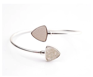Vista detallada del brazalete plateado con extremos triangulares de druzy dorado