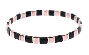 Close-up of polished black Tila beads with rose gold accents on elastic bracelet
