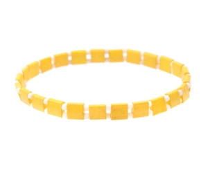 Detail of yellow Tila bead stretch bracelet with white cylindrical spacers and enamel squares