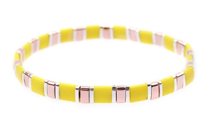 Detail view of woven Tila bead bracelet featuring yellow and rose gold enamel blocks