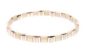 Detailed view of handmade square Tila beads in cream and metallic rose gold finish