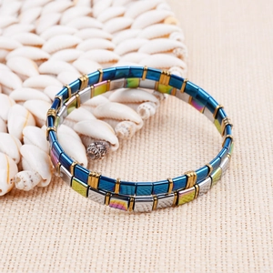 Detail of Miyuki Tila bead bracelet with colorful square stones on seashell background