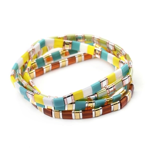Detail of multi-layered Tila bead bracelets with colorful enamel tiles and metallic accents