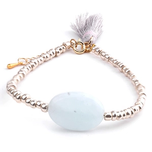 Macro detail of natural stone beaded bracelet with grey tassel and gold lobster clasp