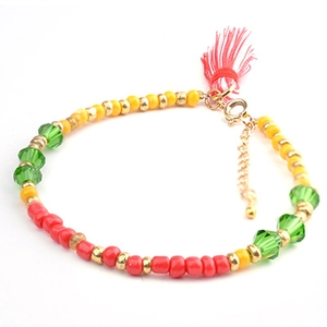 Detail of bohemian beaded bracelet featuring colorful beads, red tassels, and lobster clasp
