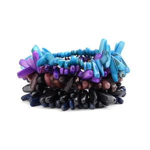 Macro-opname van kleurrijke gelaagde bohemian armbanden met onregelmatige natuursteen