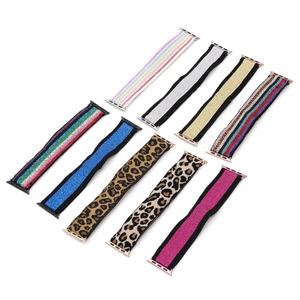 Flat lay view of eight elastic nylon Apple Watch bands in leopard, rainbow, and glitter styles