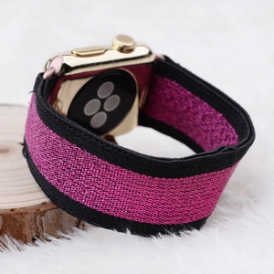 Close-up of pink and black woven elastic Apple Watch strap with subtle glitter texture