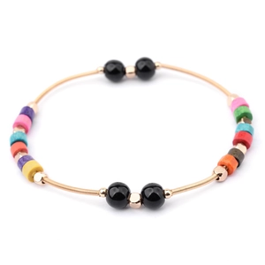 Detalle de pulsera de resorte dorada con cuentas coloridas y esferas negras decorativas