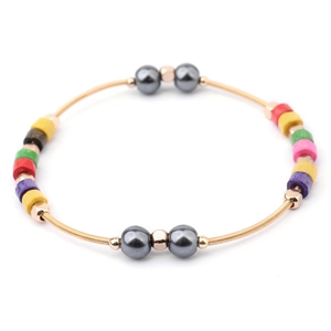 Detalle de una pulsera de cuentas de colores con espiral dorada y cuentas de hematita brillante
