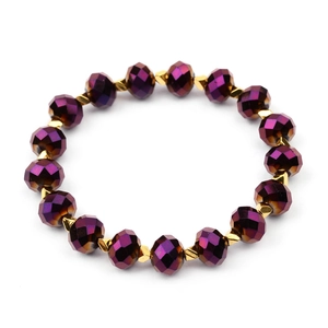 Detail van gefacetteerde paarse kristallen kralen en gouden metalen spacers op armband