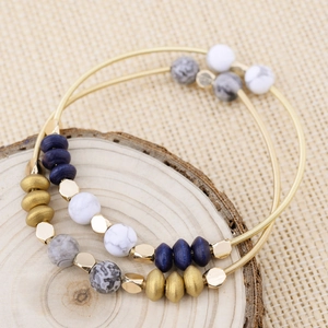 Detailed view of bohemian beaded bracelet with wood and stone beads on wood background