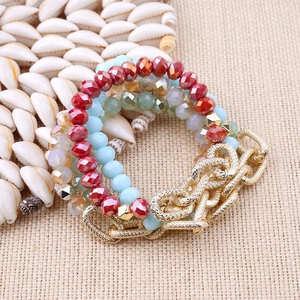 Bohemian multi-layer bracelet with faceted red and blue beads and gold chain on shells