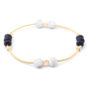 Detail of colorful beads and gold coil spring on a handmade stretch beaded bracelet